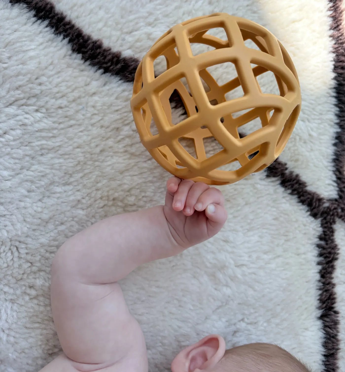 Baby playing with an orange ball toy